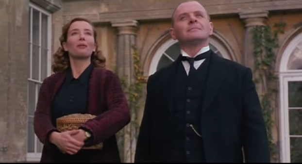 Screenshot of Remains of the Day (1993). Emma Thompson and Anthony Hopkins walking through the courtyard.