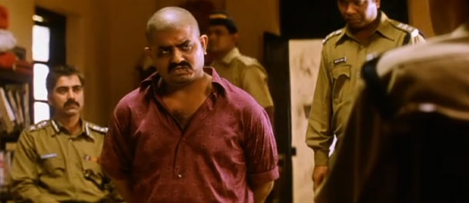 Screenshot of Black Friday (2007) a man under arrest at a police station confessing criminal behaviour and information about the crime boss.