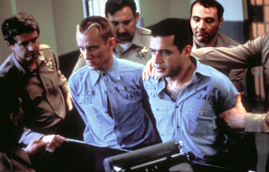 Screen shot of Greg Powell (James Woods) and James Smith (Franklyn Seales) being incarcerated. 