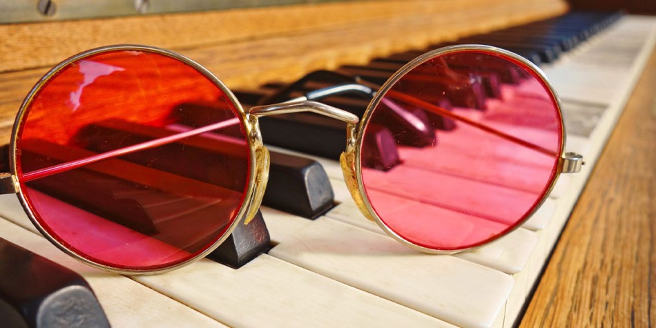 Round-framed glasses on a piano