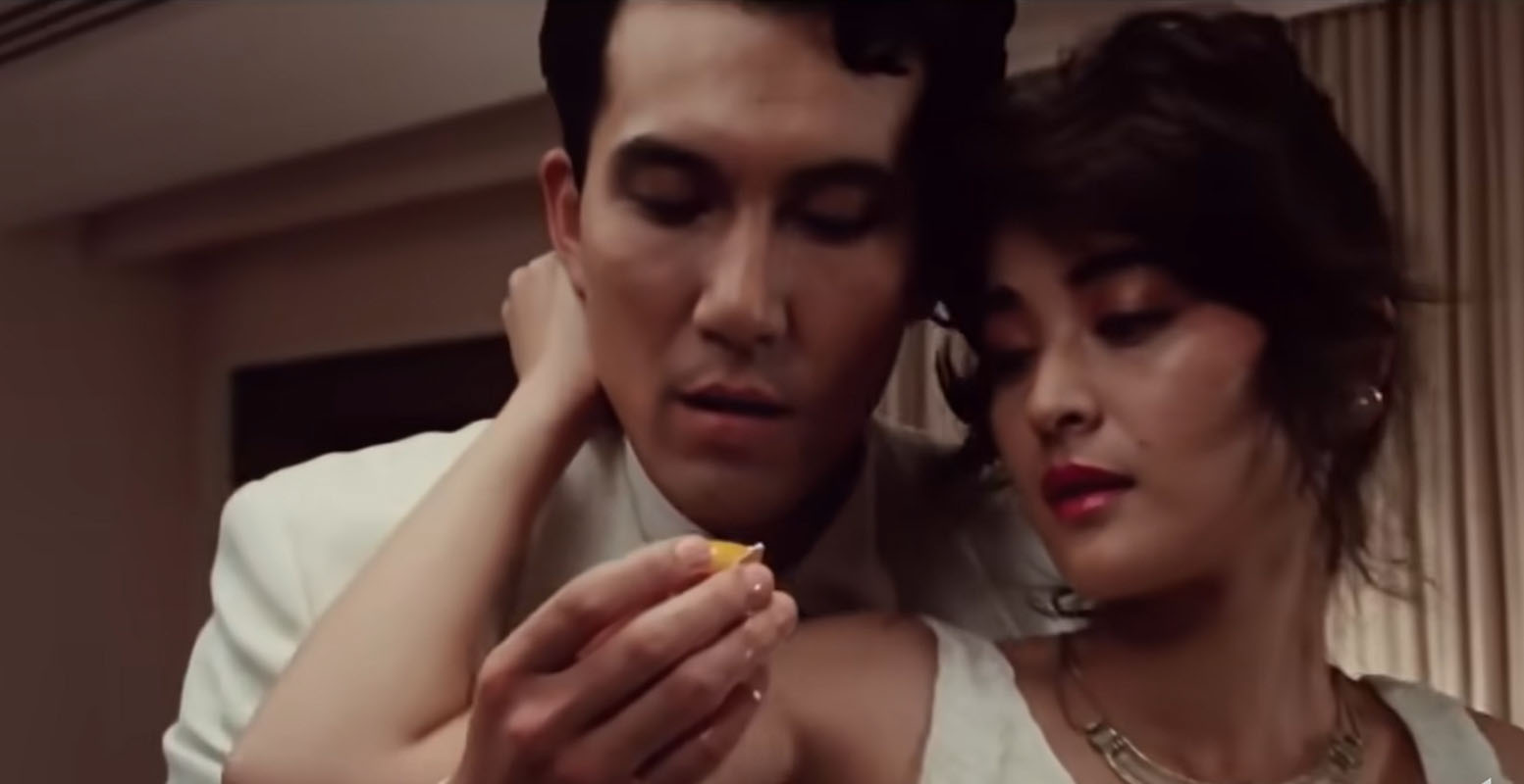 Man has a broken quail egg wrapped in his female lover's arms dress in matching white attire.